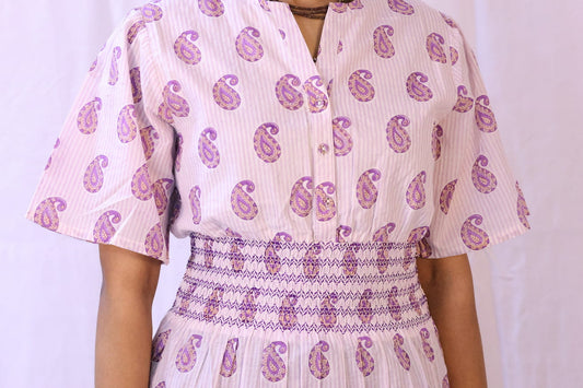 Close-up: Periwinkle paisley block print organic cotton dress with smocked waist and short sleeves.
