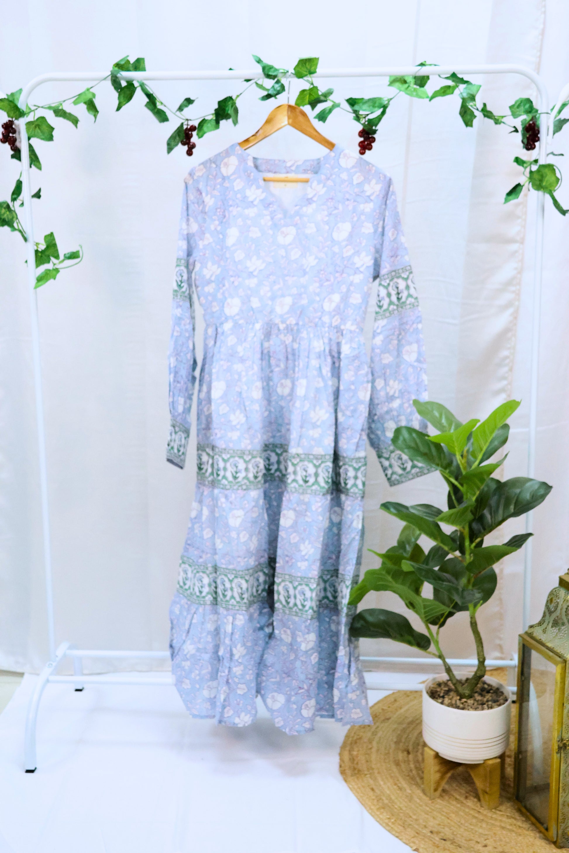 Light blue floor length blockprint dress with long sleeves on hanger.