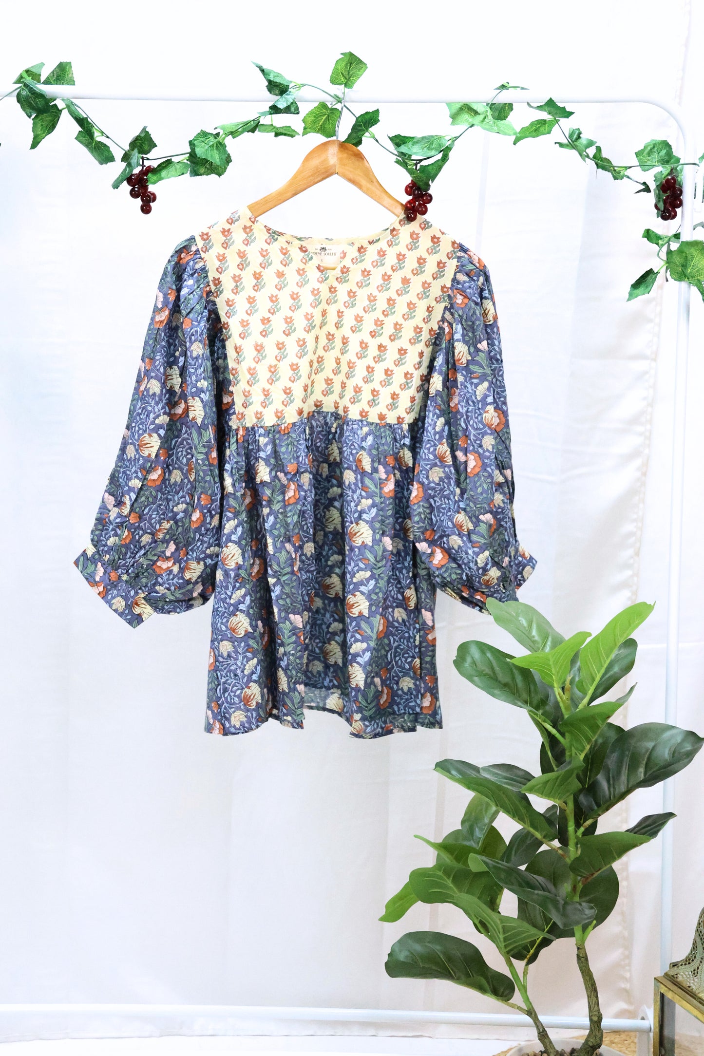On hanger blue bohemian top with puffy sleeves and hand blockprinted patterns.